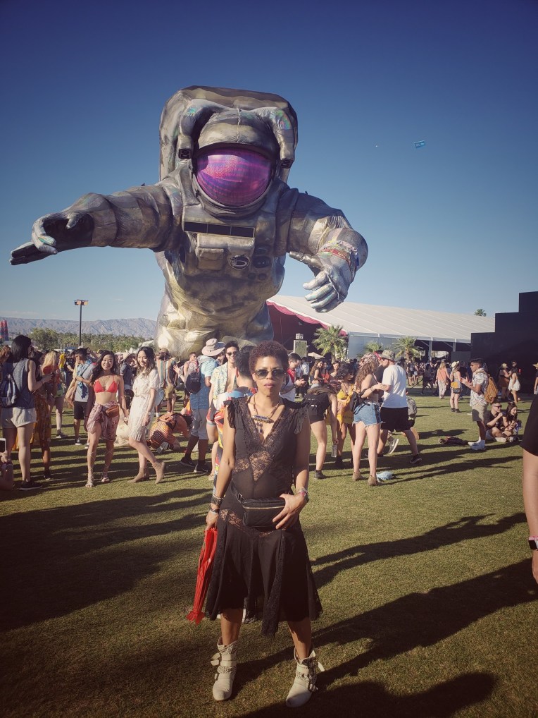 Woman in black dress in front of the Coachella spaceman