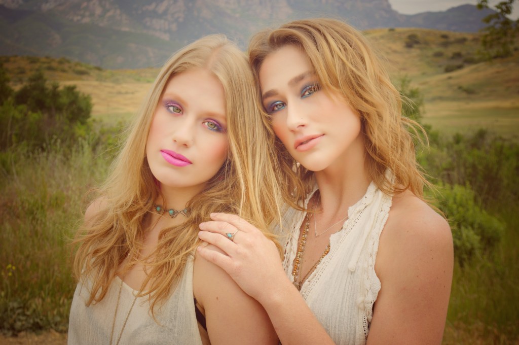 Two young women side by side in front of a mountain 
