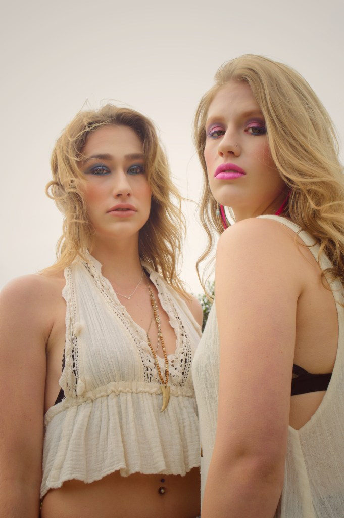 Two young women standing side by side with 80’s style makeup