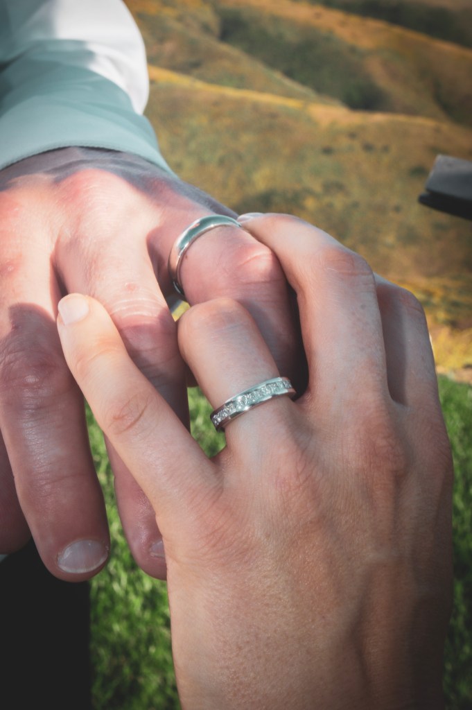 Fingers intertwined with wedding bands