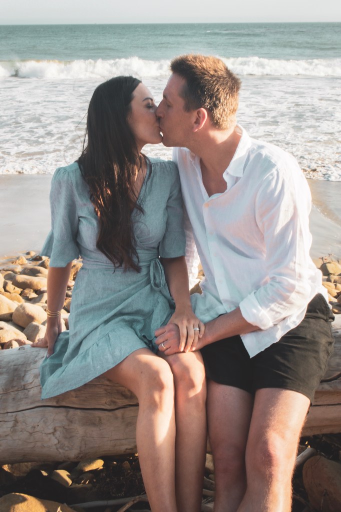 Couple on a log kissing on the beach