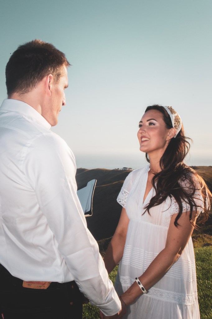 Bride smiling at the groom on a mountainside