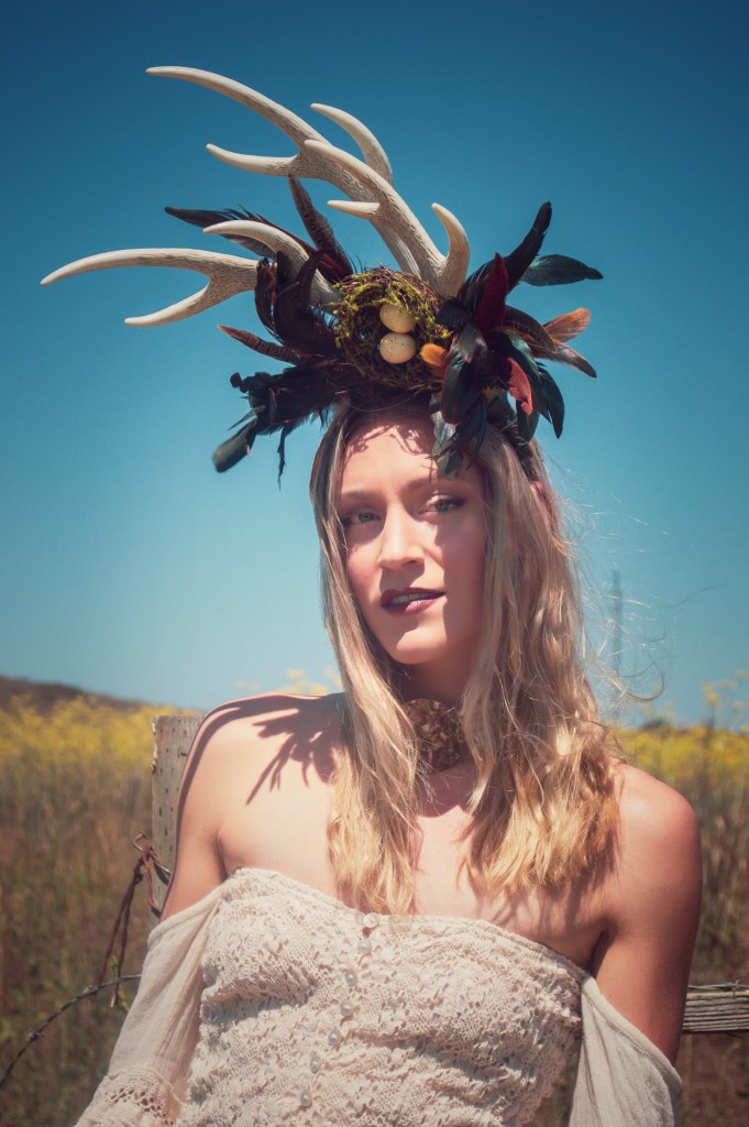 Woman with blue sky wearing a decorative horn head piece