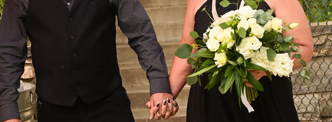 Wedding picture of a couple walking down the aisle wearing black