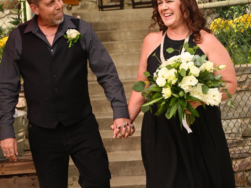 Wedding picture of a couple walking down the aisle wearing black